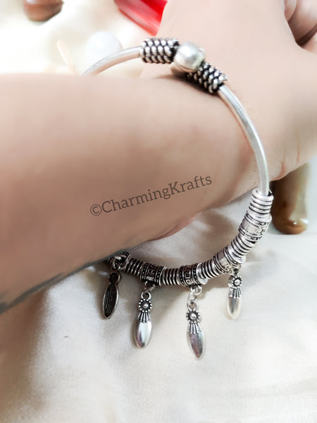 Stiff silver bracelet with hanging charms